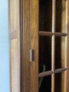 A walnut cabinet with glass doors and true mortised precision butt hinges