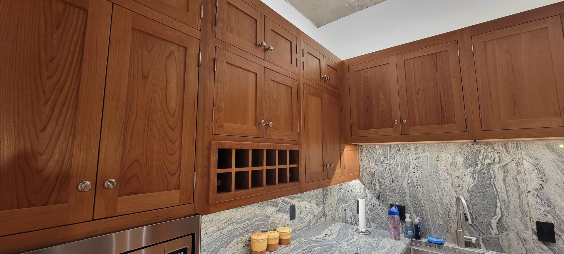 A kitchen with wooden cabinets and marble countertops.
